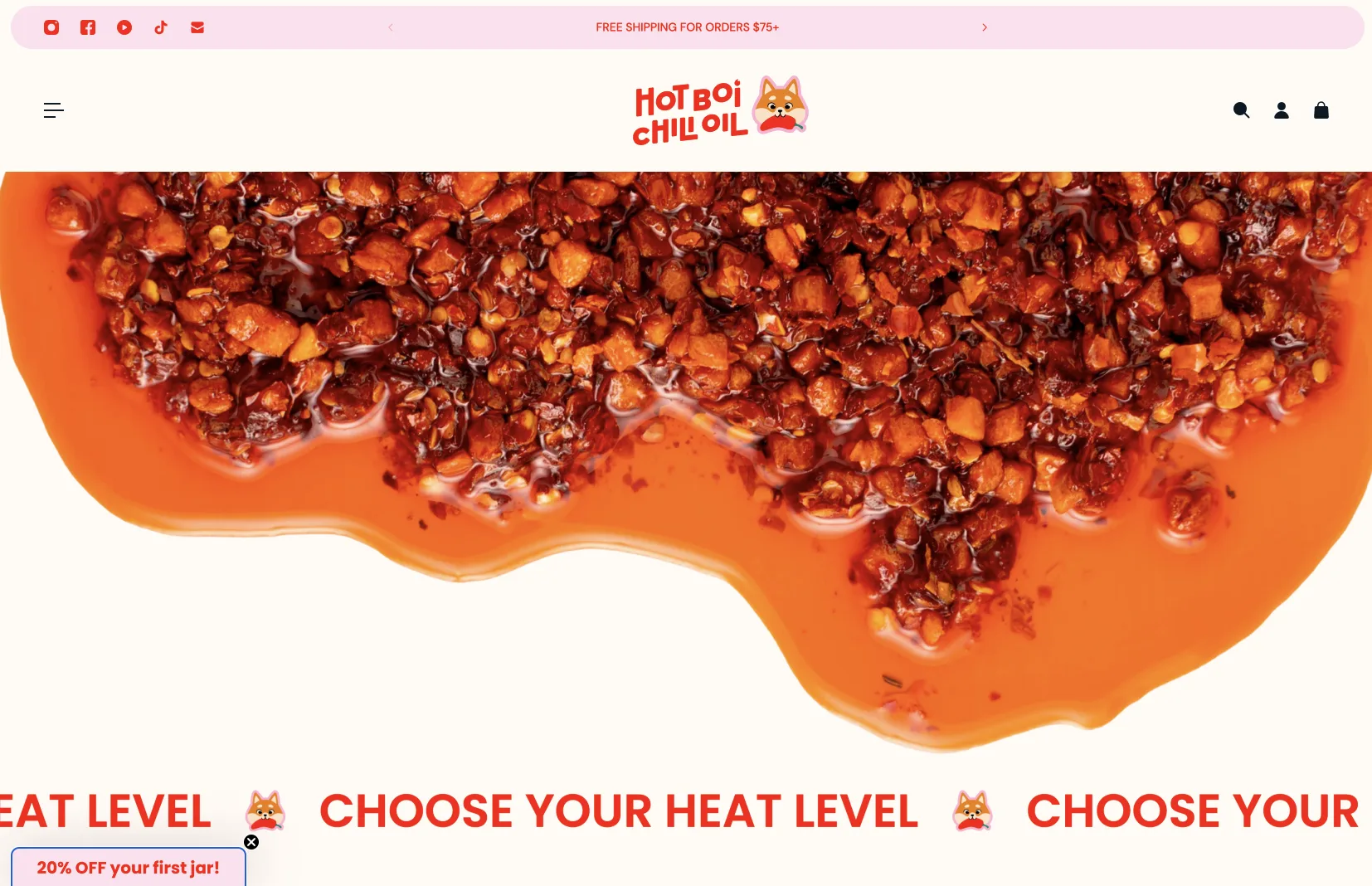 The Hot Boi Chili Oil homepage: a cream page with a red logotype and a dog mascot, a pink announcement bar, a large photo of chili oil, and a marquee reading Choose your heat level.